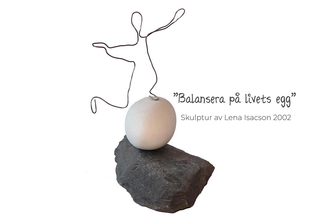 Fotograferad skulptur mot vi bakgrund. Basen när en platt granitsten. På denna vilar ett stort ägg i vit lera. På ägget balanserar en ståltrådsfigur på ett ben med det andra benet i luften och armarna åt sidorna för att hålla balansen. Text vid sidan: Balansera på livets egg.