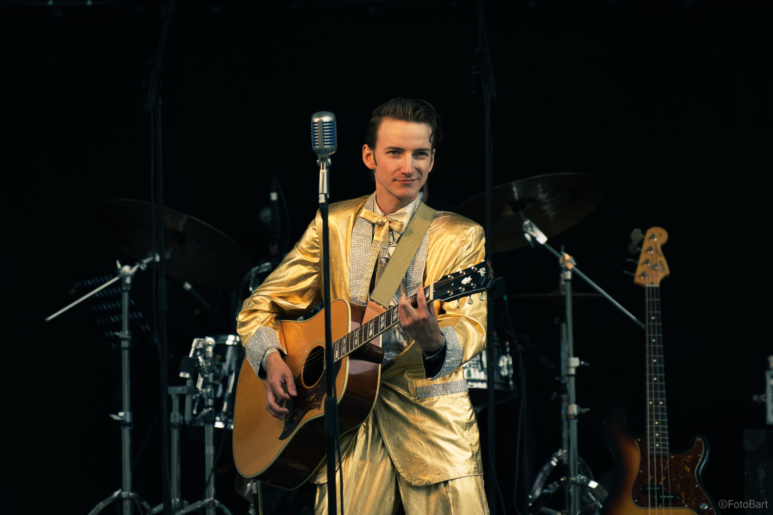Lill-Elvis, Pär Holmberg från Avesta på scenen med akustisk gitarr och guldkostym